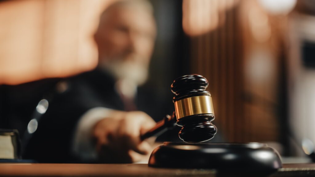 Judge striking gavel in courtroom to deliver legal decision or verdict