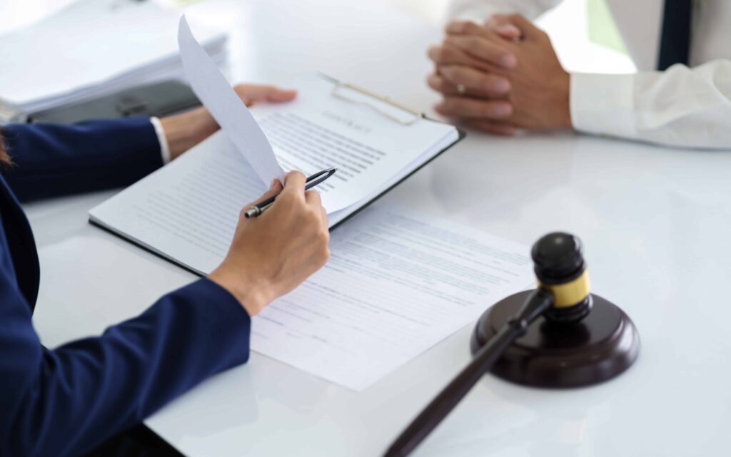 Lawyer reviewing legal documents with client during consultation at law office Lawyer reviewing legal documents with client during consultation at law office