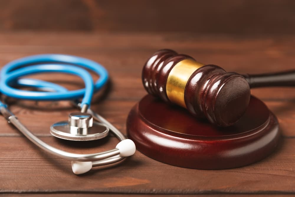 A stethoscope and hammer on a desk. Medical malpractice, Lawyer.