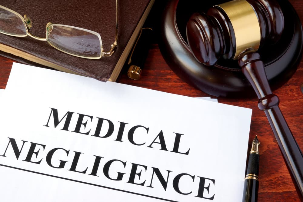 Medical Negligence form, documents and gavel on a table.